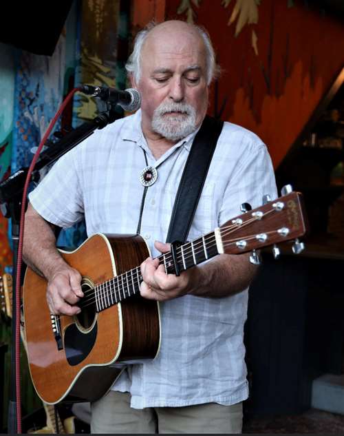 Cooper standing and playing the guitar