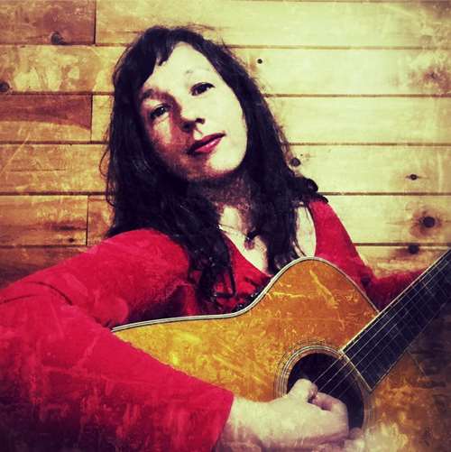 Laura holding a guitar playing a song